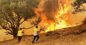 Men attempt to put out a fire in Iboudraren village